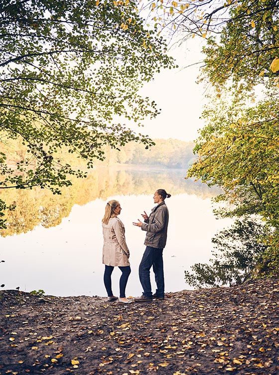 Anne Hildebrand talking to Raphael Fellmer at a lake in a forest (photo)